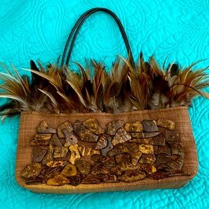 Brown handbag woven with wood pieces and feathers